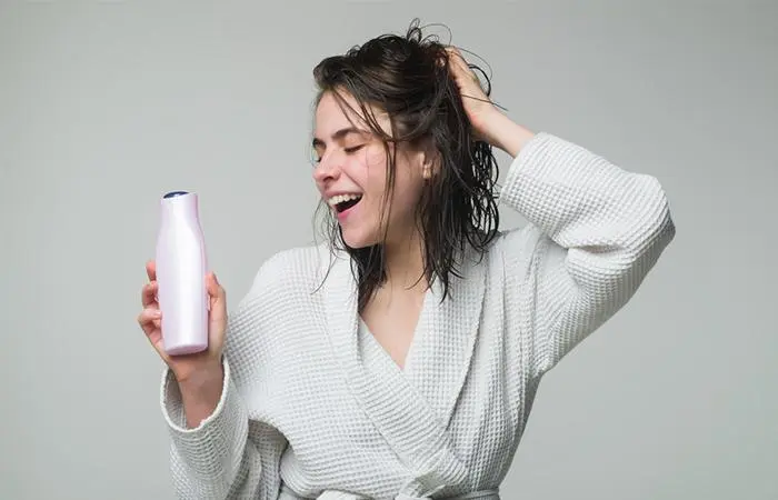 A woman holding a moisturizing shampoo