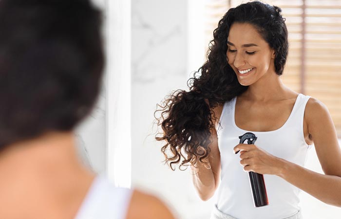 Woman spraying on her curls