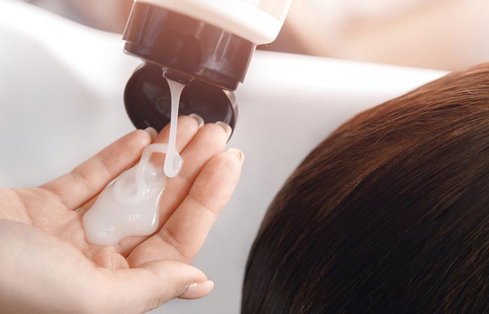 Woman applying silicone-based shampoo