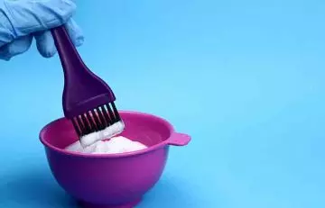 Bleaching mix and hair dye brush in a bowl 
