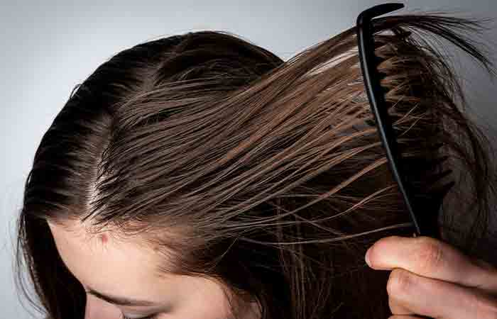 Woman combing her hair after applying serum