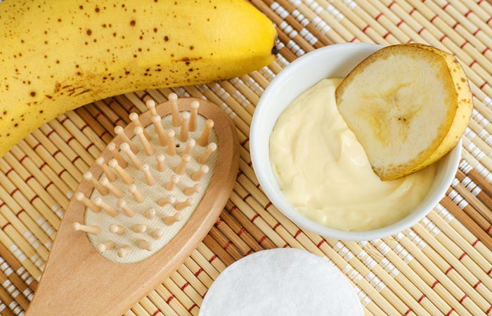 Banana and hair brush beside a bowl of banana hair mask 
