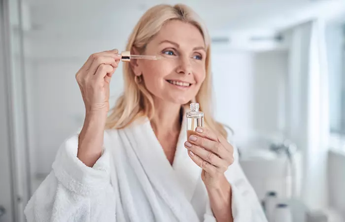 Woman applying hazelnut oil for skin elasticity