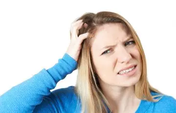 Woman scratching her head due to head lice