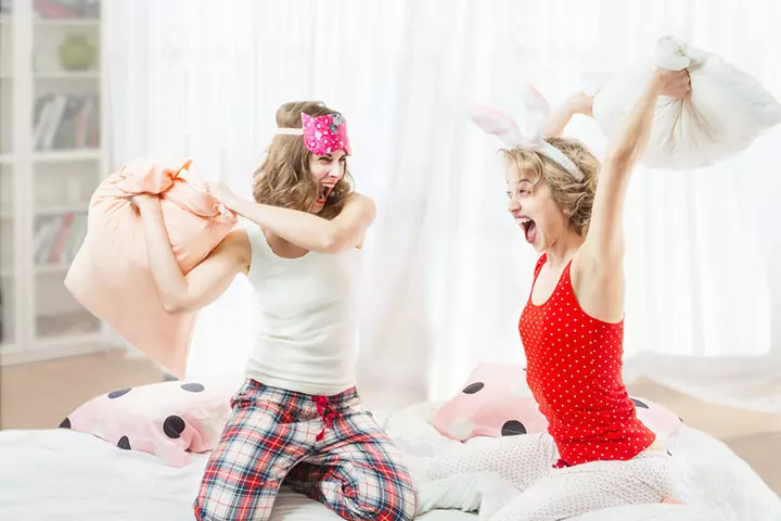 Cheerful girls playing pillow fight