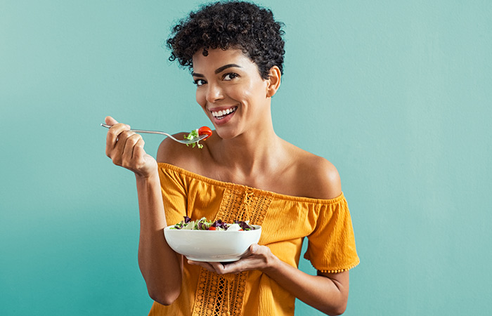Woman eating salad from a bowl