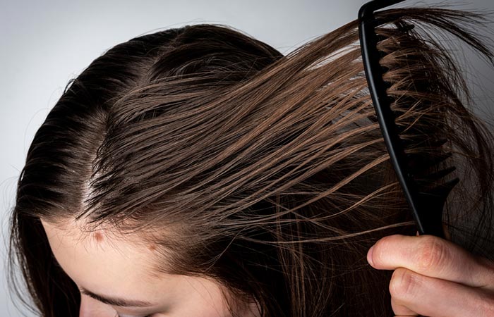 Woman brushing her greasy straight hair