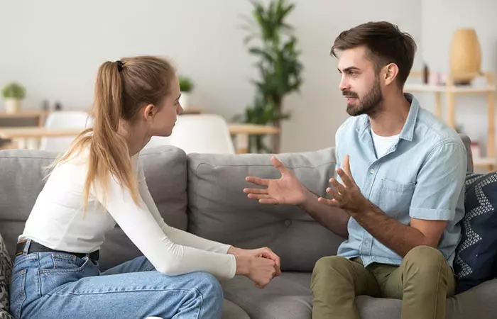 Couple sitting face-to-face and discussing about taking a break