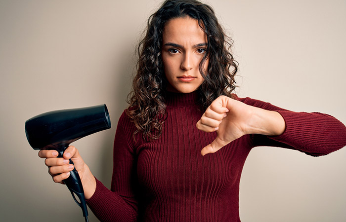 Woman making a dislike sign to indicate rejection of a blow dryer