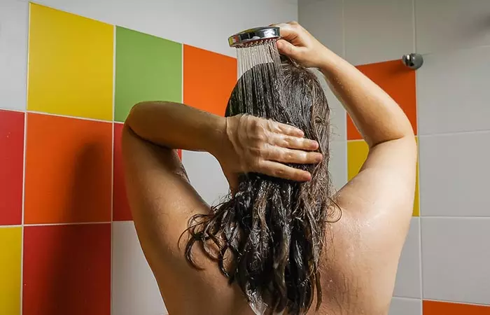 Woman washing out hair butter using a hair cleanser