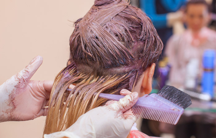 Woman applying semi-permanent hair dye for less damage