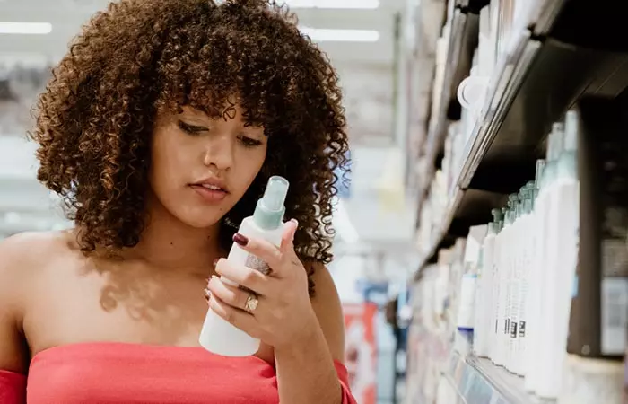 Woman checking hair care product for permed hair