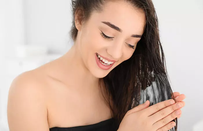 Woman applying hair mask to the tips of her hair