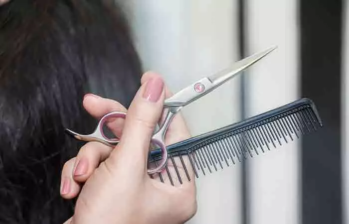 Hairdresser with comb and scissors for dusting