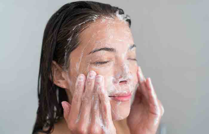Woman using a salicylic acid cleanser to unclog pores and prevent acne from whey protein