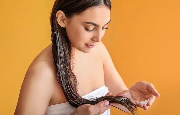 Close up of woman applying hair butter to hair.