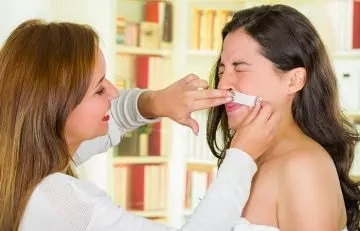 Woman having painful facial wax