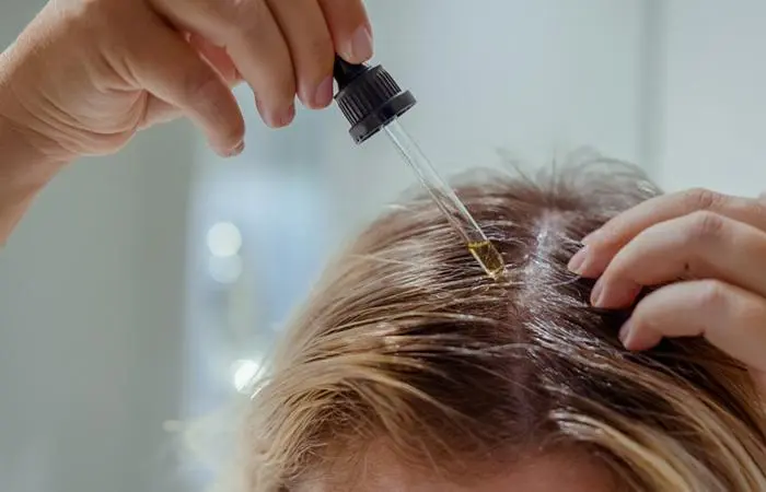 Woman oiling her hair