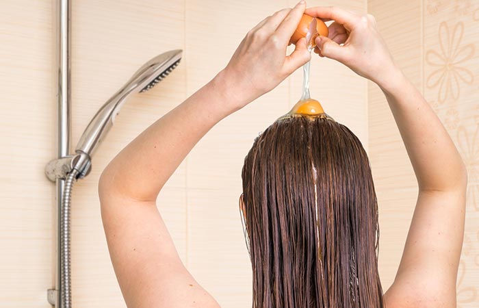 A woman applying overnight hair mask with egg