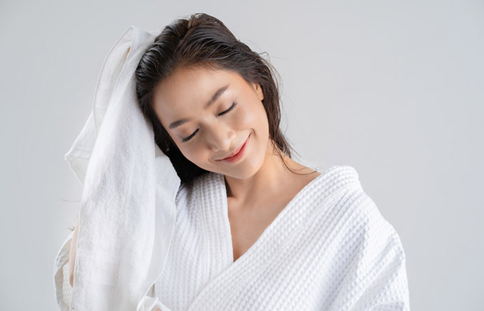 Woman gently patting her hair dry after the hair mask treatment