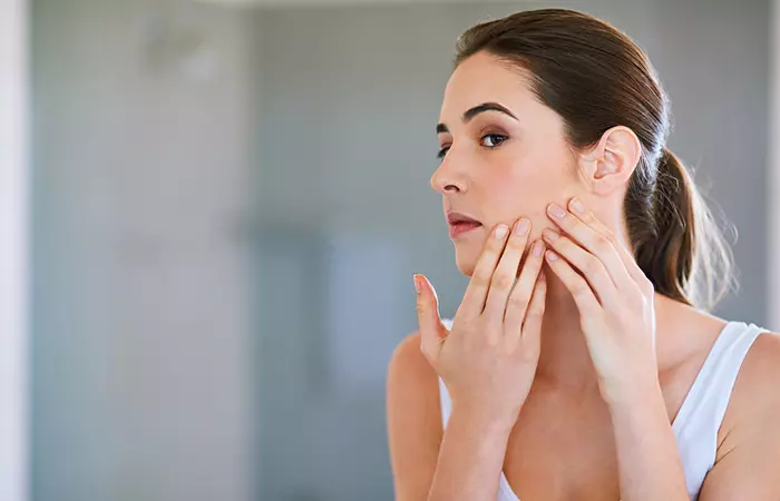 Woman looking at breakouts on the skin