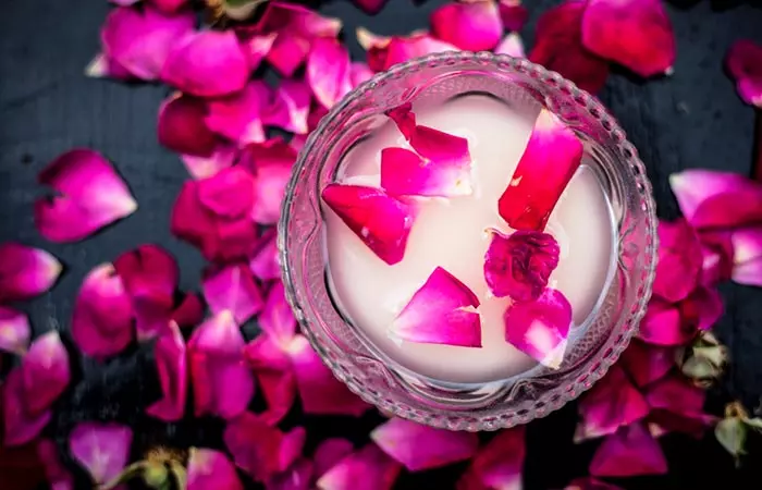 Rose petals in a bowl of milk for DIY lip mask.