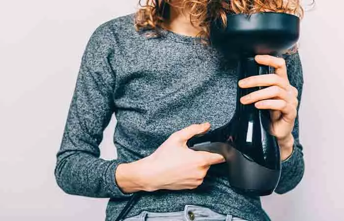 Close up of a woman diffusing her naturally curly hair.