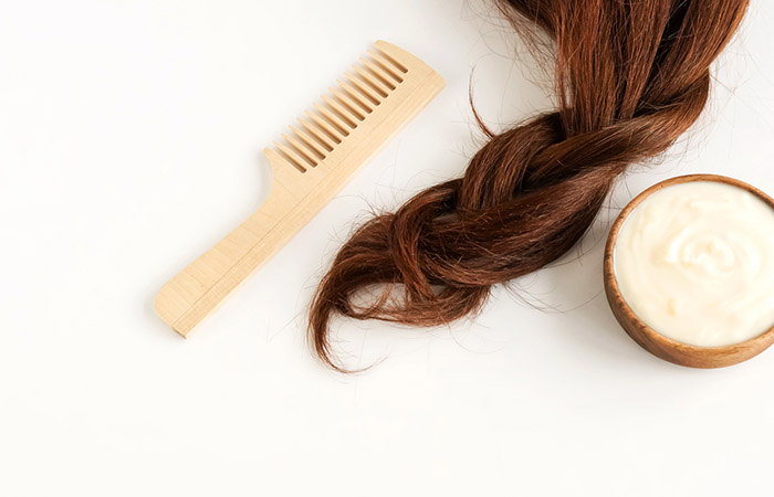 A bowl of hair mask with a wooden comb