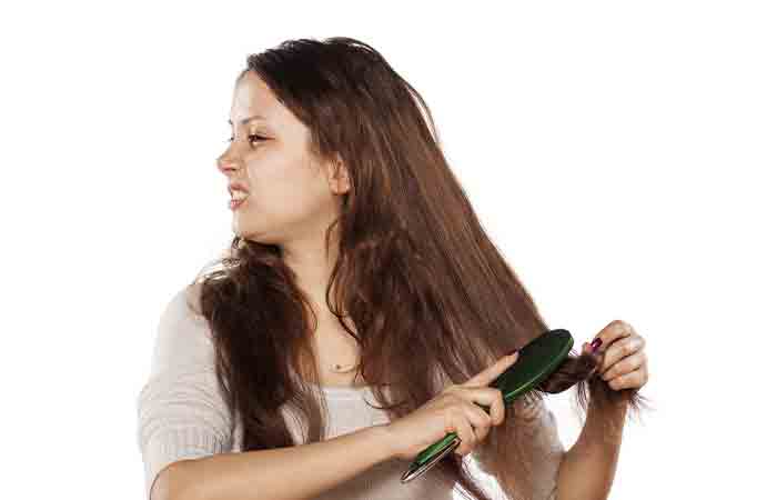 Woman is struggling to comb her unmanageable curls.