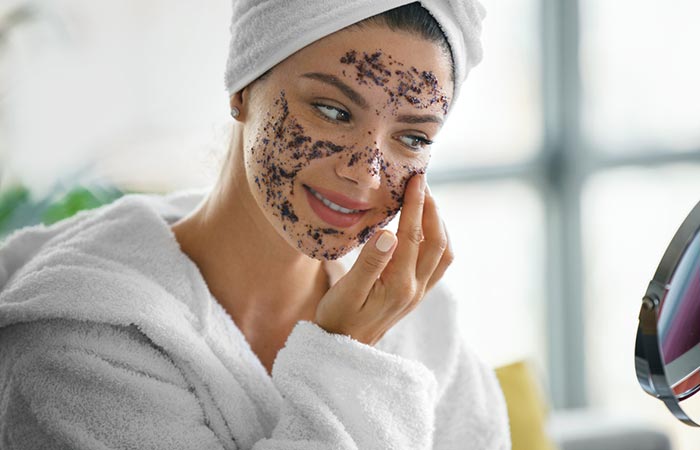 Woman exfoliating face before waxing