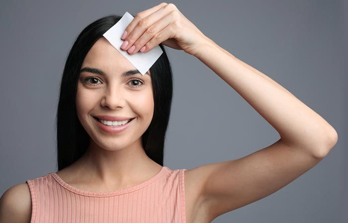 Woman dabbing a tissue on scalp to determine the type of hair