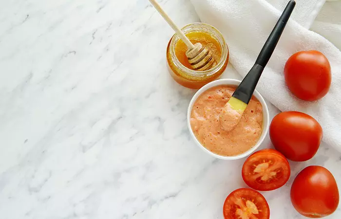 A spread of tomatoes, honey, tomato pulp, and a brush