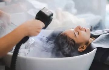 Woman getting hair spa treatment to reduce hair dye damage