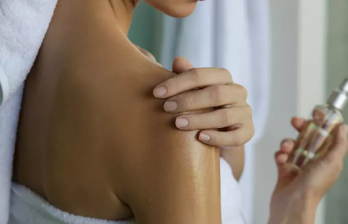 Woman moisturizing her skin with hazelnut oil