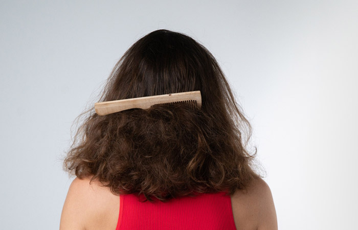 Back view of a woman who has a comb stuck in her matted hair