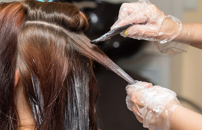 Woman getting hair gloss treatment for colour vibrancy