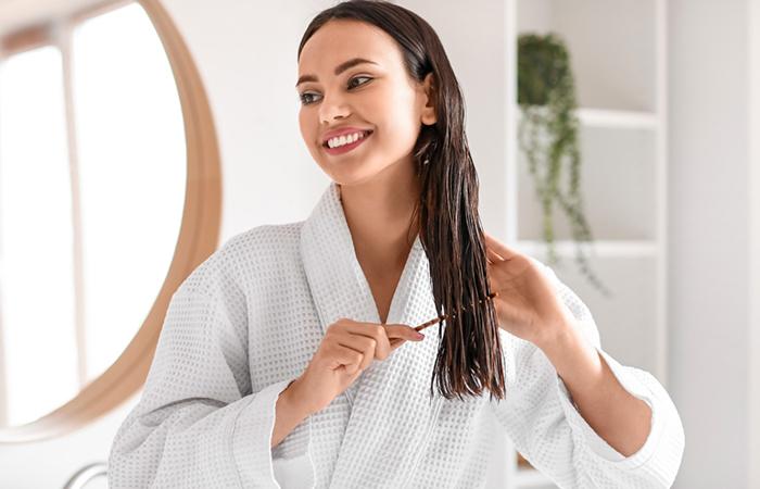 A woman applying deep conditioning hair mask on 2B hair