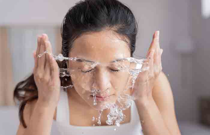 A woman cleansing her face as a part of her morning skin care routine