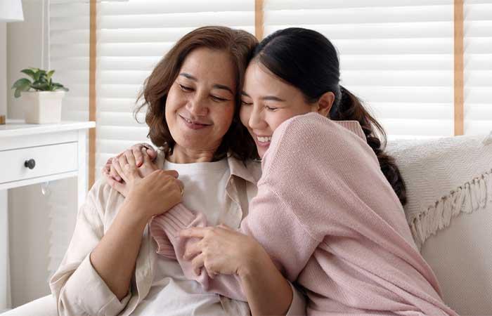 Daughter hugging mother.