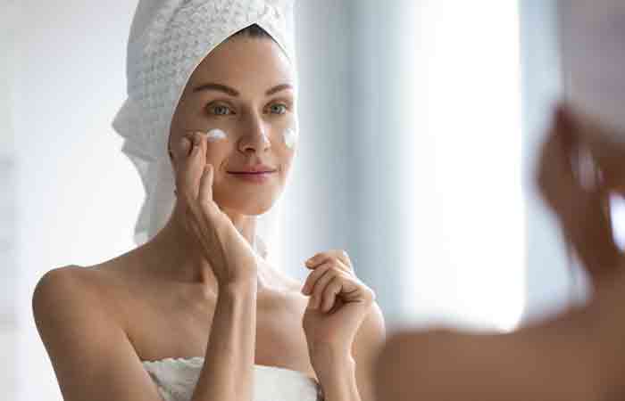 Woman applying moisturizer after the shower to ensure skin firmness