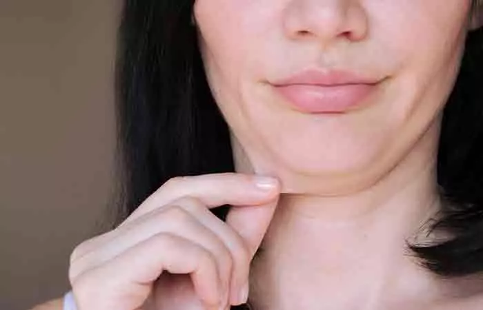 Woman pinching the sagging skin under her chin