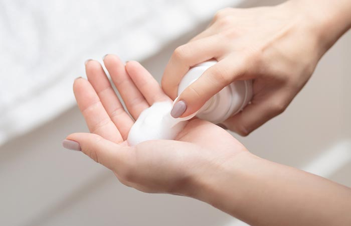 Woman using face wash with azelaic acid.