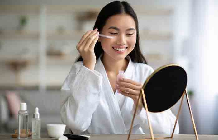 Young woman applying face serum as a part of her morning skin care routine