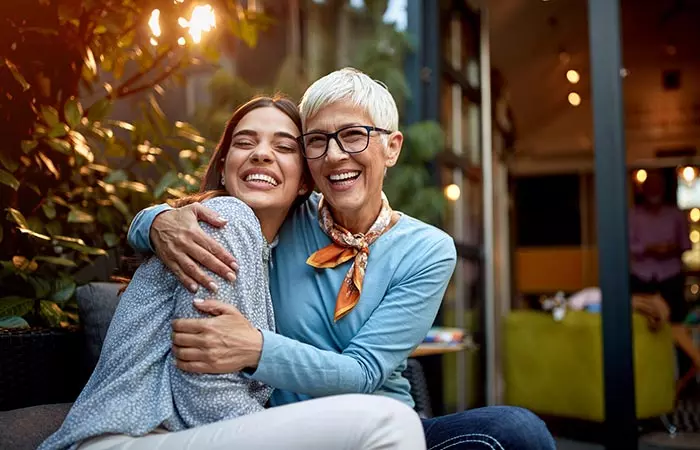 Mother hugs daughter as they laugh together