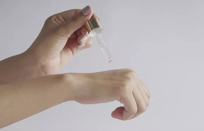 Woman applying tea tree oil to er hands to treat warts 