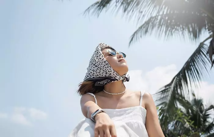 Woman using hair scarf to protect her toned hair