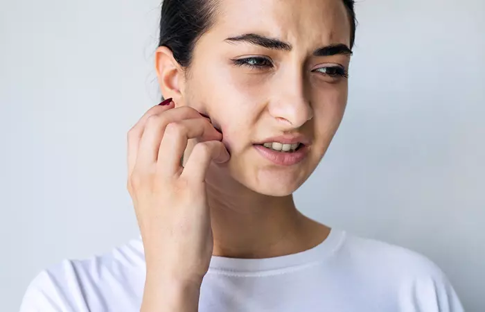 Woman itching her face