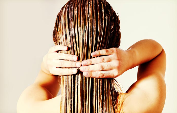 Woman applying toner on wet hair 