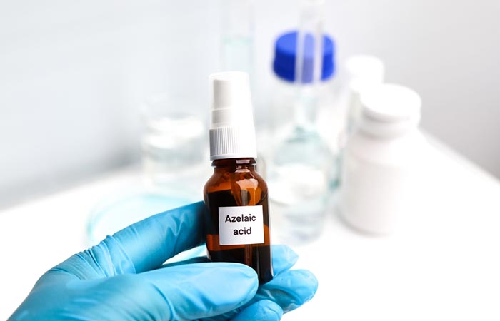 A lab worker holds a bottle of azelaic acid