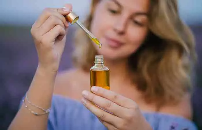 A woman holding lavender oil in a lavender field